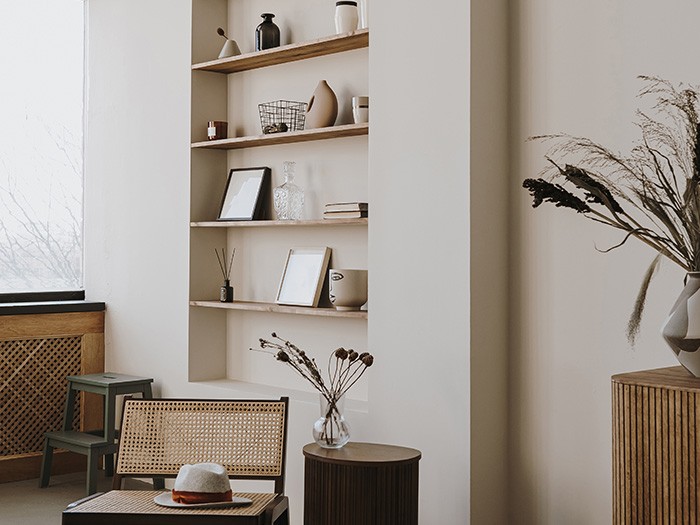 Built-in wall shelving featuring neatly arranged photos, books, and vases.